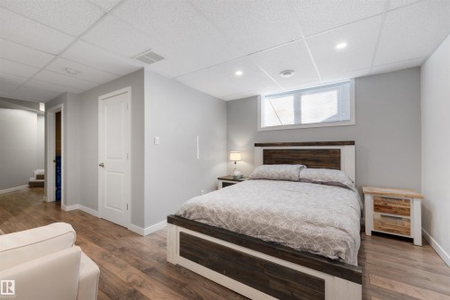 Bedroom with a paneled ceiling, wood finished floors, and recessed lighting - 81 Richmond Link, Fort Saskatchewan, AB - Indoor Photo Showing Bedroom
