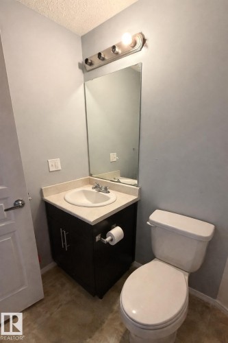 Half bath with vanity and a textured ceiling - 133 301 Clareview Station Drive, Edmonton, AB - Indoor Photo Showing Bathroom