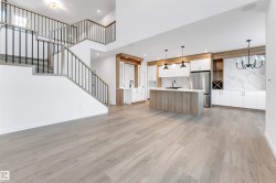 Unfurnished living room with stairs, light wood-style floors, a chandelier, a high ceiling, and recessed lighting - 
