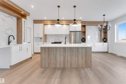 Kitchen featuring white cabinets, modern cabinets, and light stone counters - 