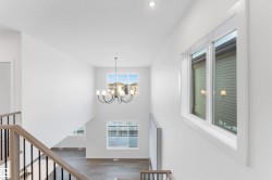 Stairs featuring a chandelier, wood finished floors, and a towering ceiling - 