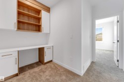 Unfurnished office featuring built in desk and light carpet - 