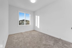Empty room with light colored carpet and baseboards - 