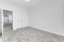 Unfurnished bedroom with light carpet and baseboards - 