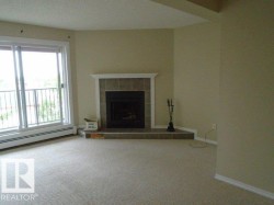 Unfurnished living room featuring a tiled fireplace and carpet floors - 