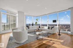 Living room featuring light wood-style flooring, recessed lighting, and floor to ceiling windows - 