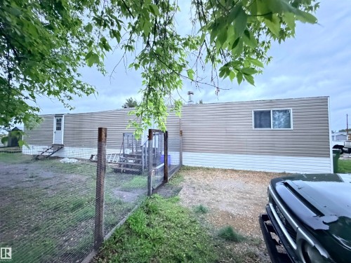 Single-story property featuring horizontal siding and a white window trim - 68 9501 104 Avenue, Westlock, AB 