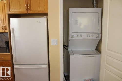 Laundry area with stacked washing machine and dryer - 330 4831 104A Street, Edmonton, AB - Indoor Photo Showing Laundry Room