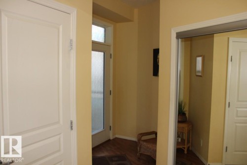 Entrance foyer with dark laminate flooring and baseboards - 330 4831 104A Street, Edmonton, AB - Indoor Photo Showing Other Room