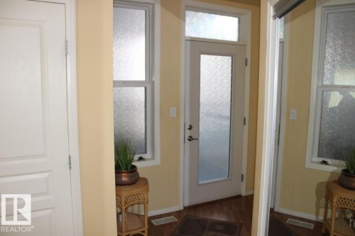 Foyer entrance featuring dark laminate flooring and baseboards - 330 4831 104A Street, Edmonton, AB - Indoor Photo Showing Other Room