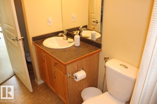 Bathroom with curtained shower, vanity, and light tile patterned flooring - 330 4831 104A Street, Edmonton, AB - Indoor Photo Showing Bathroom