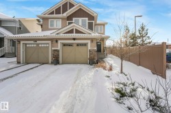 Craftsman-style house featuring stone siding, an attached garage, and board and batten siding - 