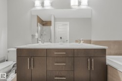 Bathroom with tiled bath, a shower, and double vanity - 