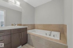 Bathroom featuring vanity and a garden tub - 