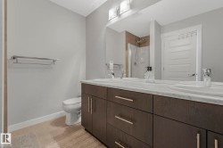Full bathroom featuring double vanity, a shower, and light tile patterned flooring - 