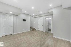 Finished below grade area with light wood finished floors, stairway, and recessed lighting - 