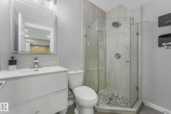 Bathroom with vanity, a stall shower, tasteful backsplash, and dark tile patterned floors - 