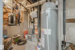 Utilities featuring water heater, electric panel, and heating unit - 