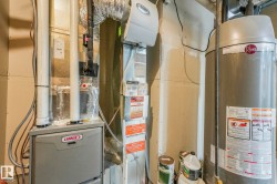 Utility room featuring water heater and heating unit - 