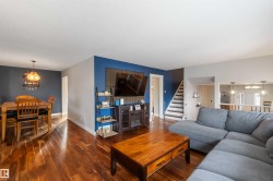Living room with suspended lighting and wood finished floors - 