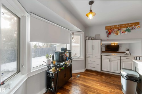 Kitchen featuring white cabinets, pendant lighting, dark wood-type flooring, and light countertops - 6 Garraway Pl, St. Albert, AB - Indoor