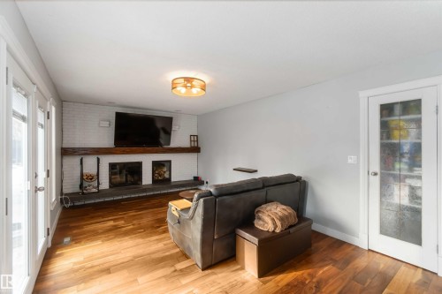 Living area featuring wood finished floors and a fireplace - 6 Garraway Pl, St. Albert, AB - Indoor With Fireplace