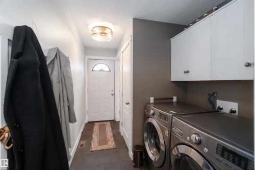 Laundry area with independent washer and dryer, cabinet space, and a textured ceiling - 6 Garraway Pl, St. Albert, AB - Indoor Photo Showing Laundry Room