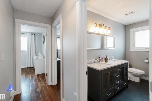 Bathroom featuring double vanity, a textured ceiling, and dark wood finished floors - 6 Garraway Pl, St. Albert, AB - Indoor Photo Showing Bathroom