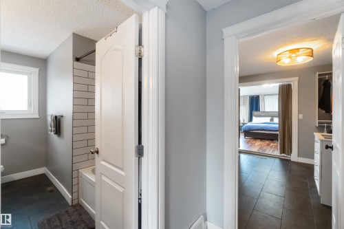 Bathroom with  shower combination, a textured ceiling, dark tile patterned flooring, vanity, and ensuite bathroom - 6 Garraway Pl, St. Albert, AB - Indoor Photo Showing Other Room