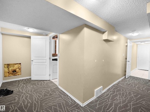 Hallway with a textured ceiling, carpet, and washer / dryer - 791 Abbottsfield Road, Edmonton, AB - Indoor Photo Showing Other Room