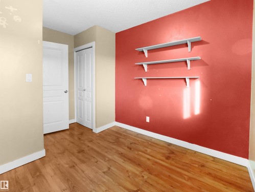 Unfurnished bedroom featuring light wood-style flooring, a textured ceiling, and a closet - 791 Abbottsfield Road, Edmonton, AB - Indoor Photo Showing Other Room