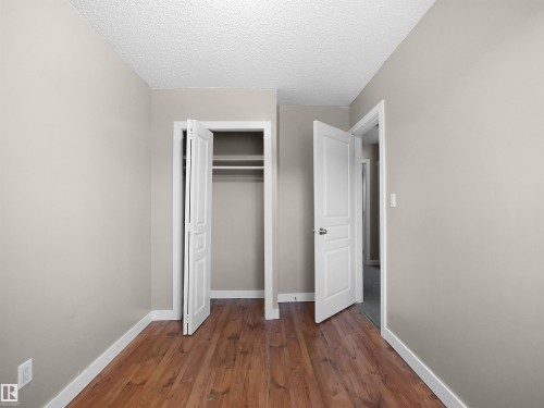 Unfurnished bedroom featuring dark wood finished floors, a textured ceiling, and a closet - 791 Abbottsfield Road, Edmonton, AB - Indoor Photo Showing Other Room