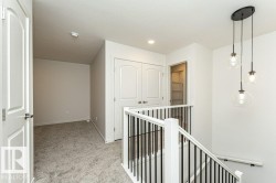 Hall with an upstairs landing and light carpet - 