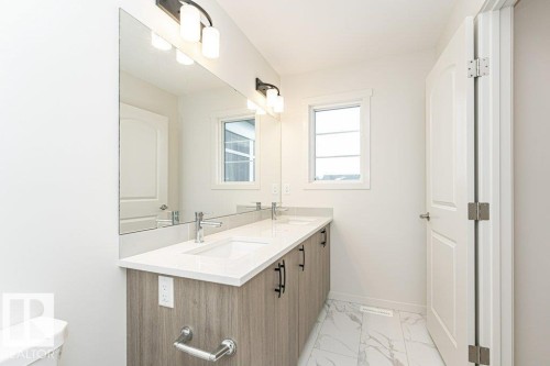 Bathroom featuring double vanity and light marble finish floors - 3972 Wren Loop, Edmonton, AB - Indoor Photo Showing Bathroom
