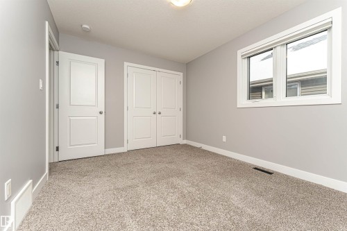 Unfurnished bedroom with light colored carpet and a closet - 3611 Keswick Boulevard, Edmonton, AB - Indoor Photo Showing Other Room