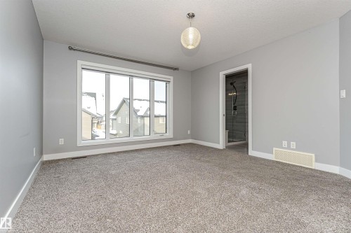 Unfurnished room featuring light carpet and a textured ceiling - 3611 Keswick Boulevard, Edmonton, AB - Indoor Photo Showing Other Room