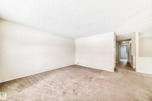 Empty room with light carpet and a textured ceiling - 5308 20 Avenue, Edmonton, AB - Indoor Photo Showing Other Room