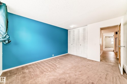 Unfurnished bedroom with carpet flooring, a closet, and a textured ceiling - 5308 20 Avenue, Edmonton, AB - Indoor Photo Showing Other Room