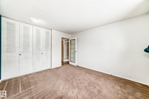 Unfurnished bedroom with carpet, a textured ceiling, and a closet - 5308 20 Avenue, Edmonton, AB - Indoor Photo Showing Other Room