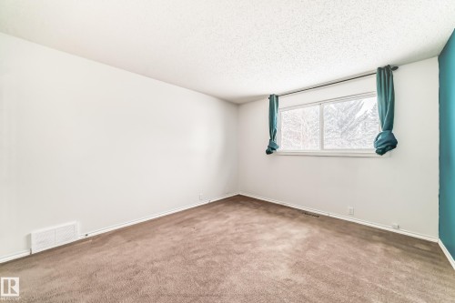 Empty room featuring carpet and a textured ceiling - 5308 20 Avenue, Edmonton, AB - Indoor Photo Showing Other Room