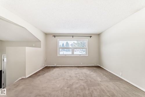 Unfurnished room featuring light carpet and a textured ceiling - 5308 20 Avenue, Edmonton, AB - Indoor Photo Showing Other Room