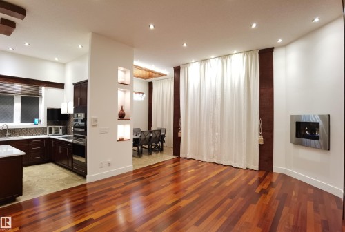 Kitchen featuring dark wood finish cabinetry, light wood finished floors, light stone counters, and recessed lighting - 169 Callaghan Drive, Edmonton, AB - Indoor