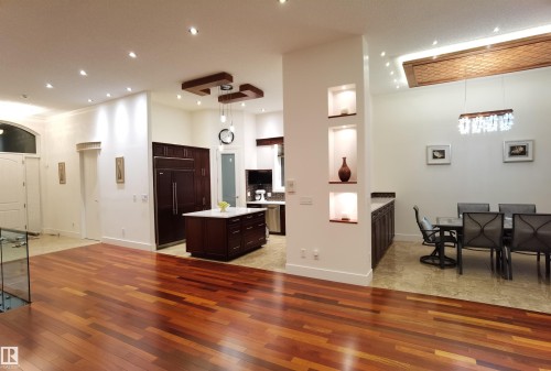 Kitchen featuring dark wood finish cabinetry, paneled fridge, a kitchen island, a high ceiling, and light wood-type flooring - 169 Callaghan Drive, Edmonton, AB - Indoor Photo Showing Other Room