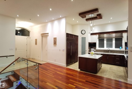 Kitchen featuring dark wood finish cabinetry, light wood-type flooring, a kitchen island, recessed lighting, and light stone countertops - 169 Callaghan Drive, Edmonton, AB - Indoor Photo Showing Other Room