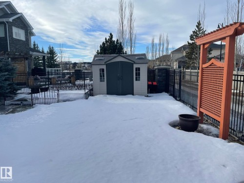 Yard layered in snow featuring a fenced backyard, a storage unit, and a patio - 169 Callaghan Drive, Edmonton, AB - Outdoor