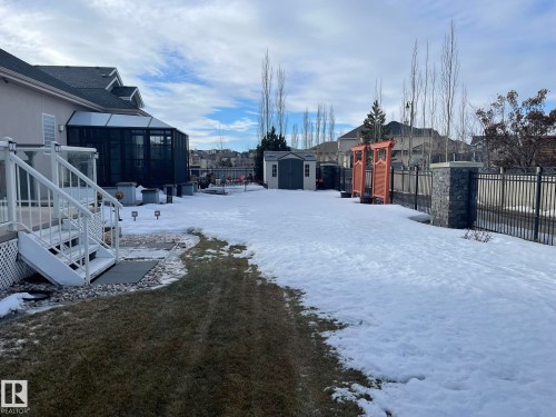 Yard layered in snow with a residential view, a shed, glass enclosure, and a sunroom - 169 Callaghan Drive, Edmonton, AB - Outdoor