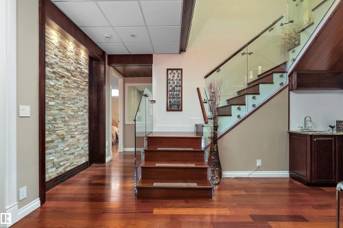 Stairs with a paneled ceiling and wood finished floors - 169 Callaghan Drive, Edmonton, AB - Indoor Photo Showing Other Room