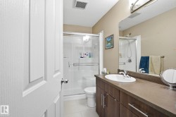Full bath with vanity, a stall shower, a textured ceiling, and light tile patterned floors - 