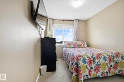 Bedroom featuring light colored carpet and a textured ceiling - 
