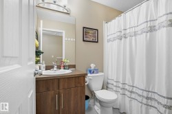 Bathroom featuring curtained shower, vanity, a textured ceiling, and light tile patterned floors - 